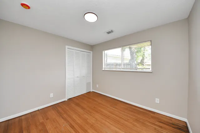 a view of an empty room with wooden floor