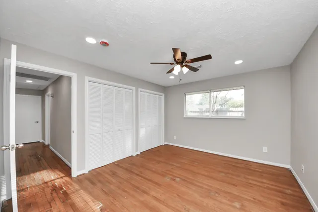 a view of empty room with wooden floor