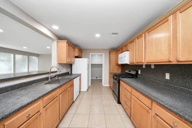 a kitchen with stainless steel appliances granite countertop counter space a sink and a large window