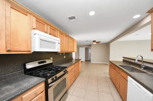 a kitchen with stainless steel appliances granite countertop a sink and a stove