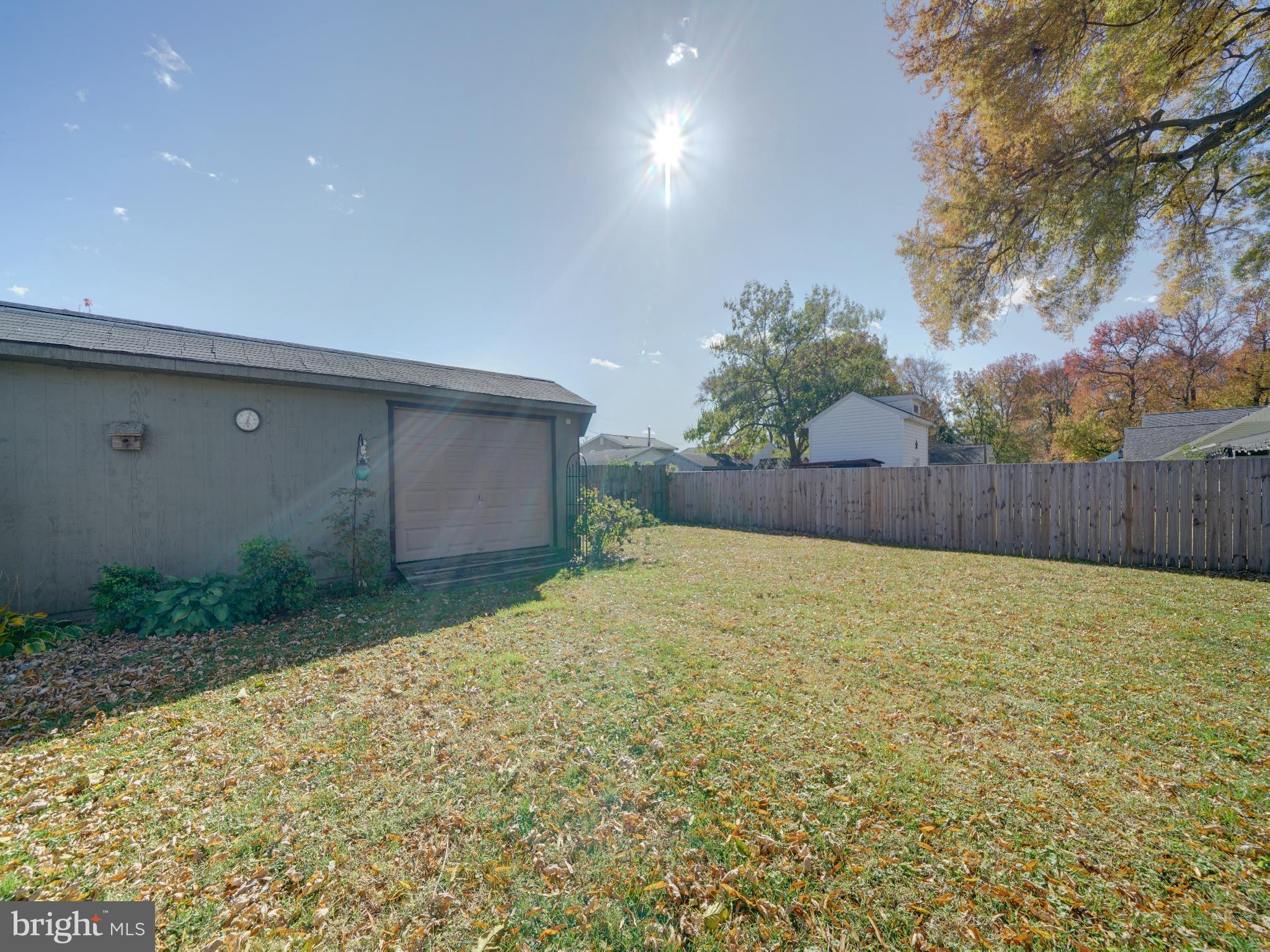 7819 Appletree Road Pasadena, MD 21122 - Photo 36 of 59 Spacious backyard under a bright blue sky.