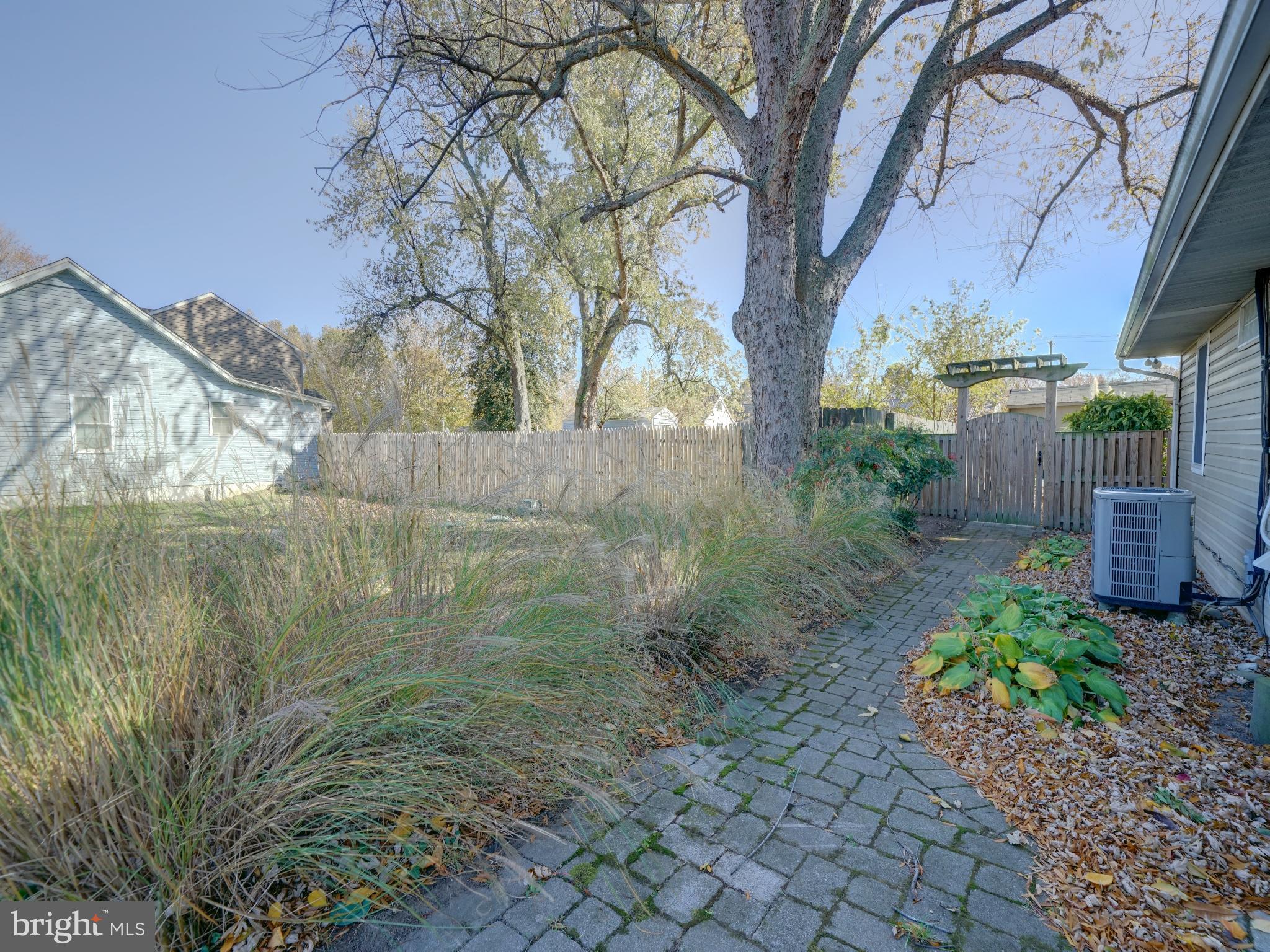 7819 Appletree Road Pasadena, MD 21122 - Photo 49 of 59 Serene garden path under autumn skies.