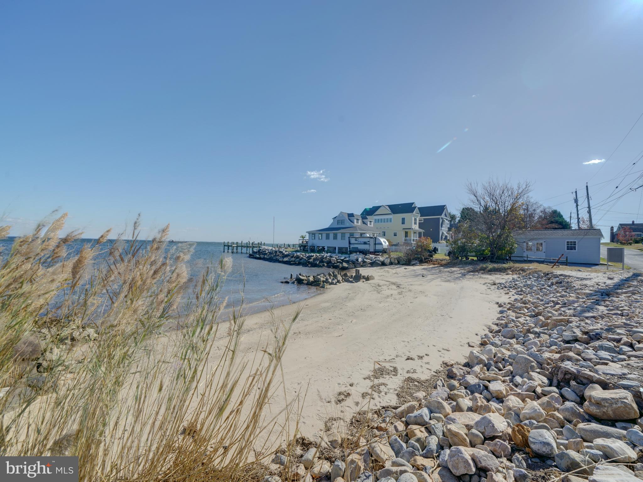 7819 Appletree Road Pasadena, MD 21122 - Photo 59 of 59 Serene waterfront view with sandy shore.