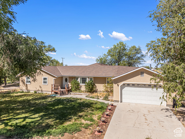 4310 South 4000 W Road Deseret, UT 84624 - Photo 1 of 1 Single story home with stucco siding, a front yard, a garage, driveway, and a shingled roof