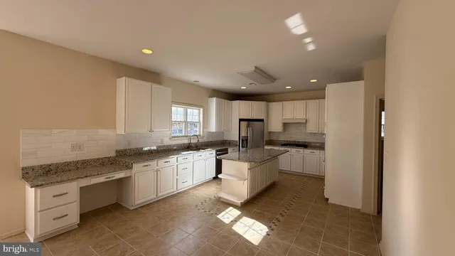 a spacious bathroom with a granite countertop sink a mirror and a bathtub