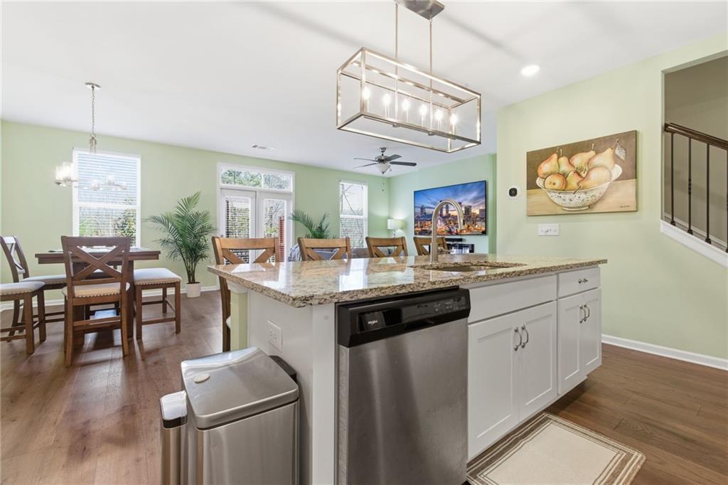 2106 Garden Place Atlanta, GA 30316 - Photo 11 of 37 a kitchen with stainless steel appliances granite countertop a refrigerator a sink dishwasher a dining table and chairs with wooden floor