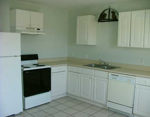 13953 Ketch Street Corpus Christi, TX 78418 - Photo 3 of 3 a kitchen with white cabinets and a stove