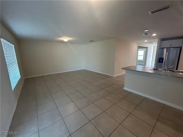 an empty room with a fireplace and windows