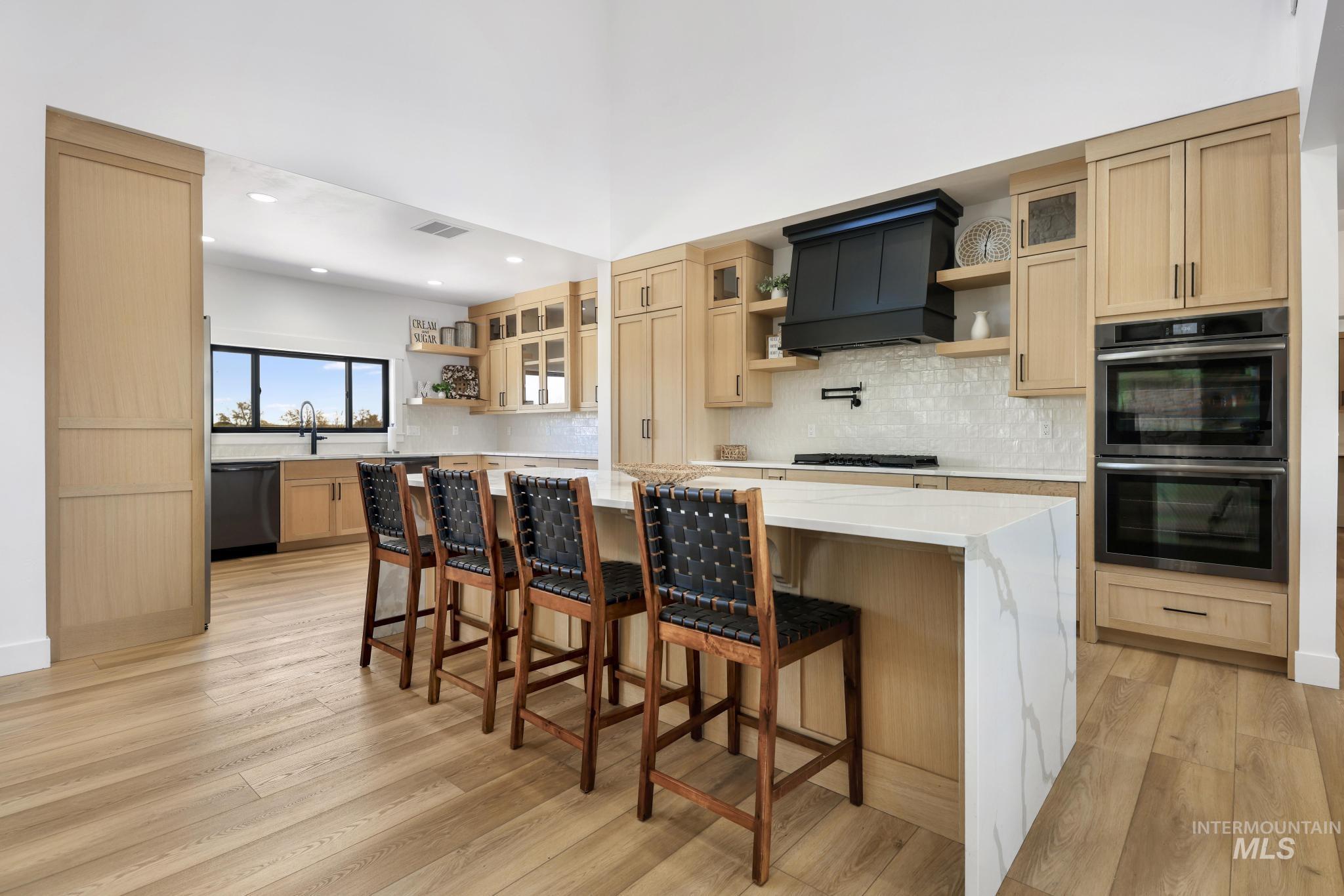 4288 North 2400 East Filer, ID 83328 - Photo 11 of 50 Kitchen with open shelves, double oven, a spacious island, a kitchen breakfast bar, and light wood finish cabinetry