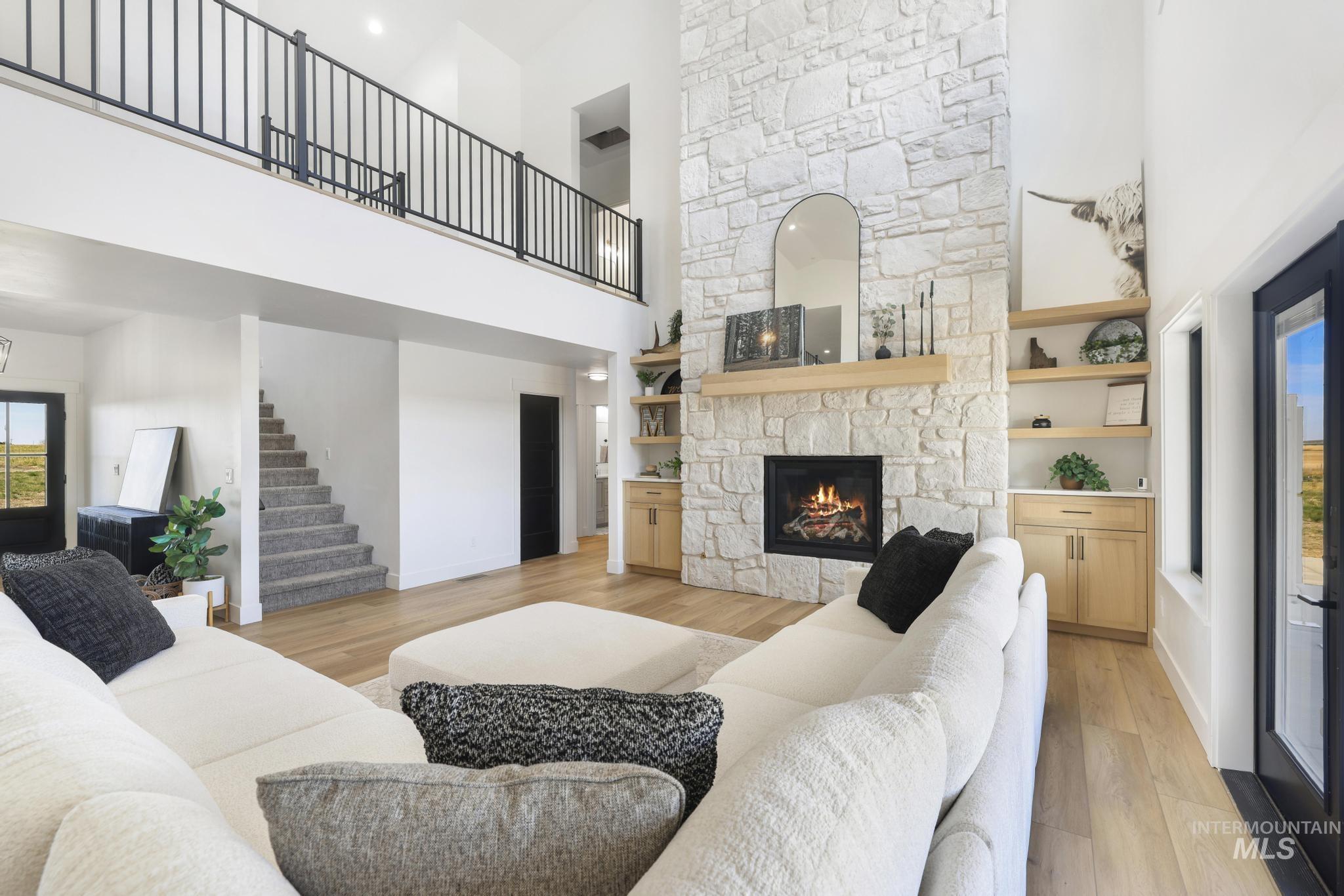 4288 North 2400 East Filer, ID 83328 - Photo 16 of 50 Living area featuring light wood-style floors, a stone fireplace, and a high ceiling