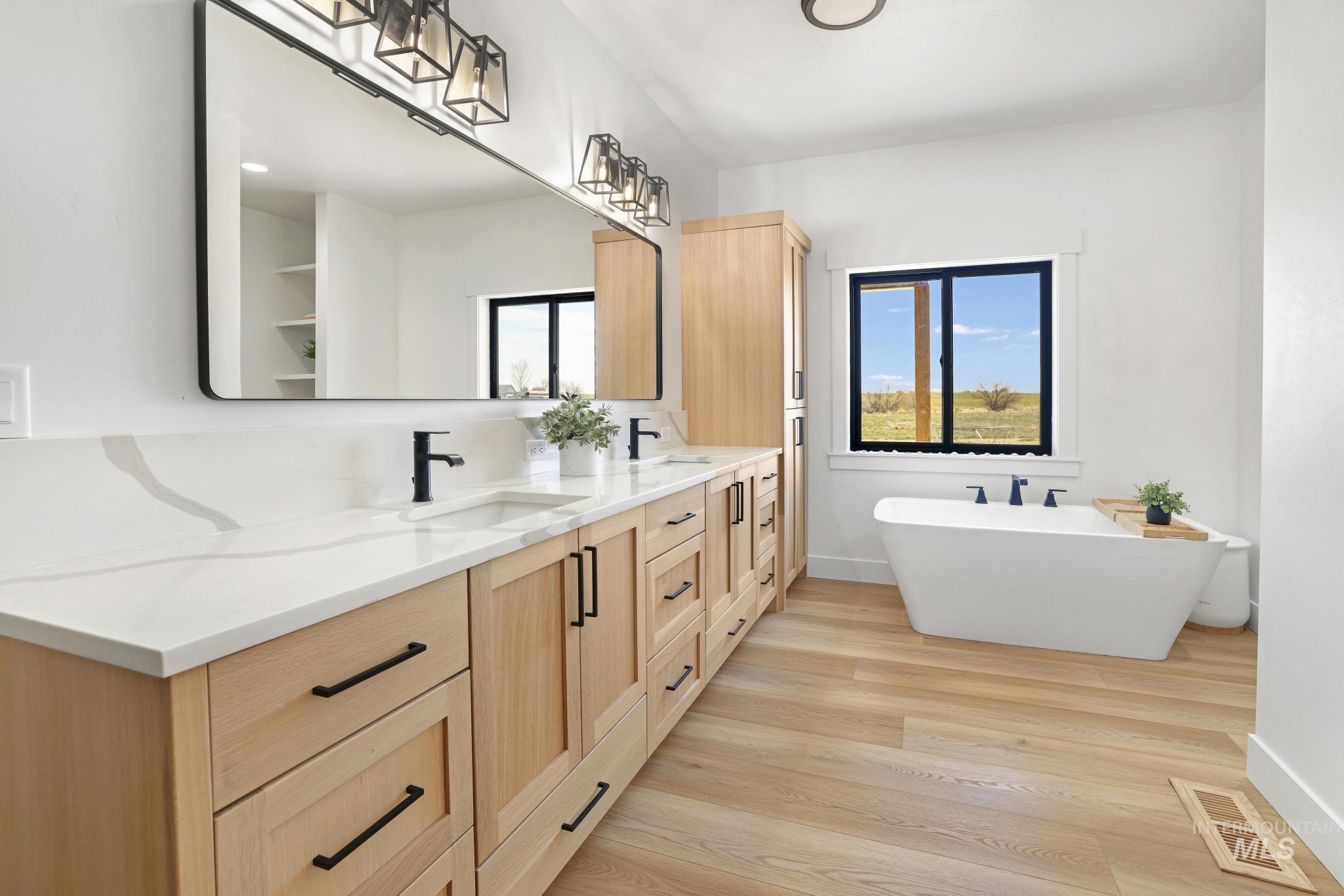 4288 North 2400 East Filer, ID 83328 - Photo 24 of 50 Full bathroom with double vanity, light wood-type flooring, and a freestanding bath