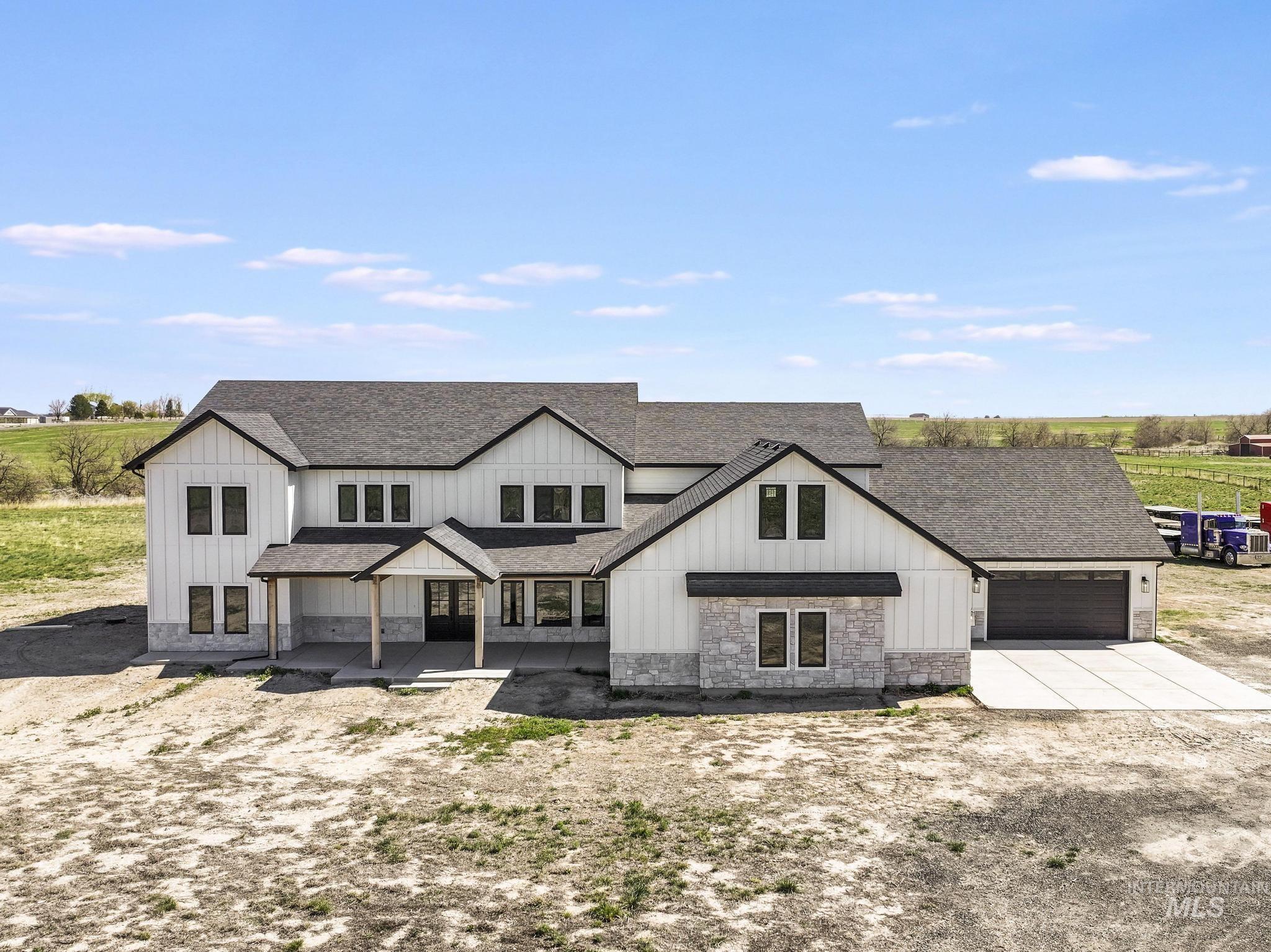 4288 North 2400 East Filer, ID 83328 - Photo 5 of 50 Modern farmhouse style home featuring roof with shingles, driveway, board and batten siding, stone siding, and a porch