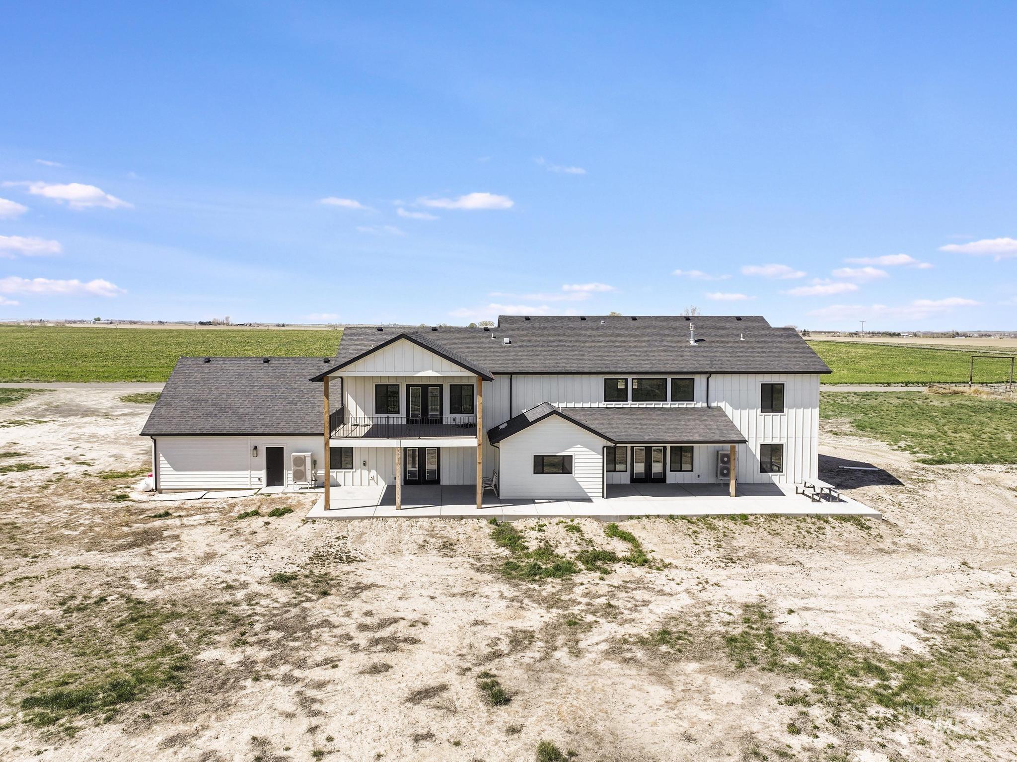 4288 North 2400 East Filer, ID 83328 - Photo 7 of 50 Back of property featuring a patio, a view of rural / pastoral area, a shingled roof, and a balcony