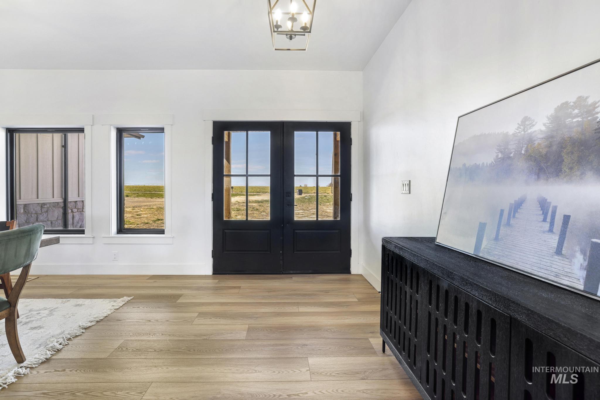 4288 North 2400 East Filer, ID 83328 - Photo 9 of 50 Entryway with french doors, light wood finished floors, healthy amount of natural light, and a chandelier