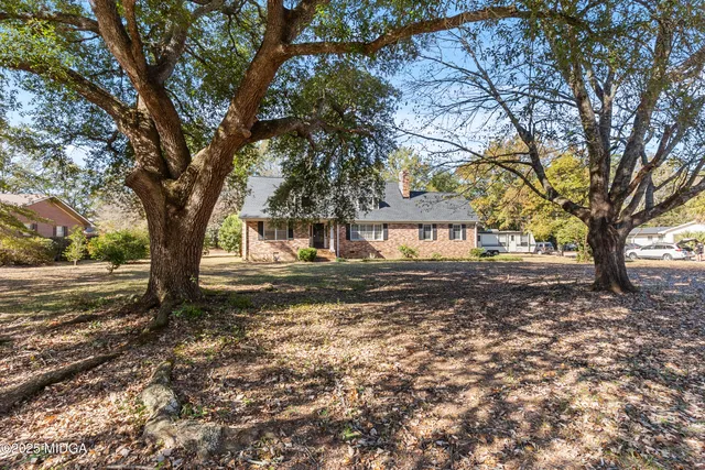 a view of dirt yard with a tree