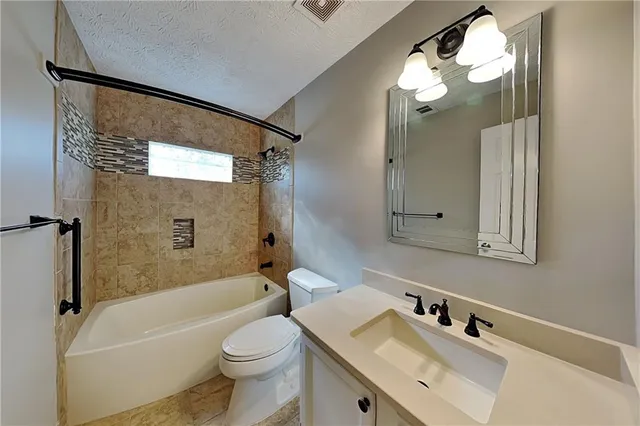 a bathroom with a sink a toilet a mirror a bathtub and shower