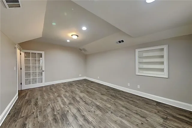 a view of empty room with wooden floor and windows