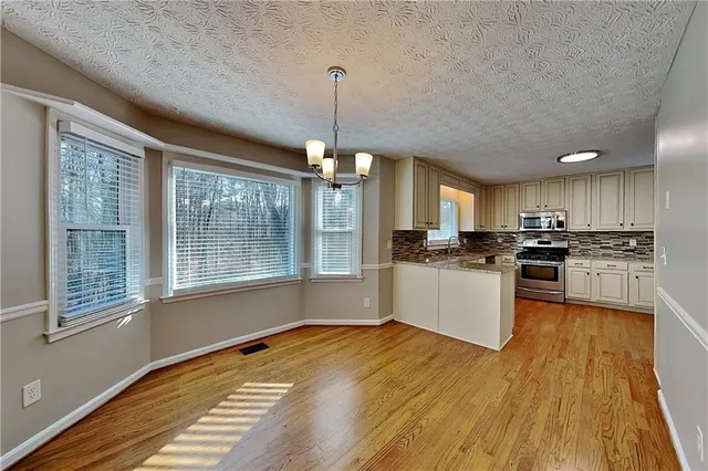 a kitchen with a refrigerator and white cabinets