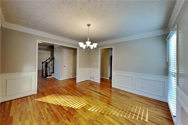 a view of a livingroom with a chandelier and wooden floor