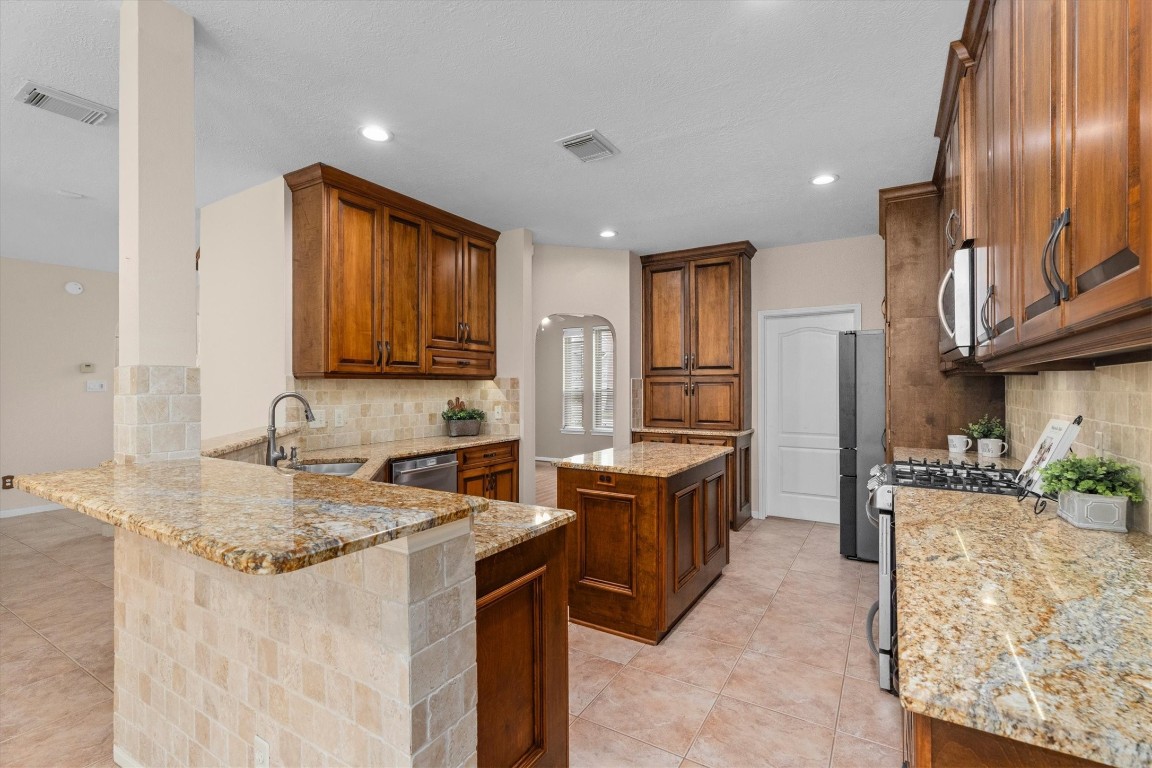 19703 Holly Walk Spring, TX 77388 - Photo 19 of 42 a kitchen with stainless steel appliances granite countertop a sink stove and refrigerator