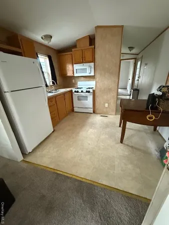 a kitchen with stainless steel appliances a refrigerator a sink a stove top oven a counter space and cabinets