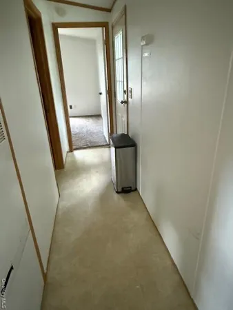 an empty room with mirror and windows