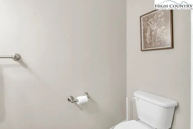 a white toilet sitting next to a white wall
