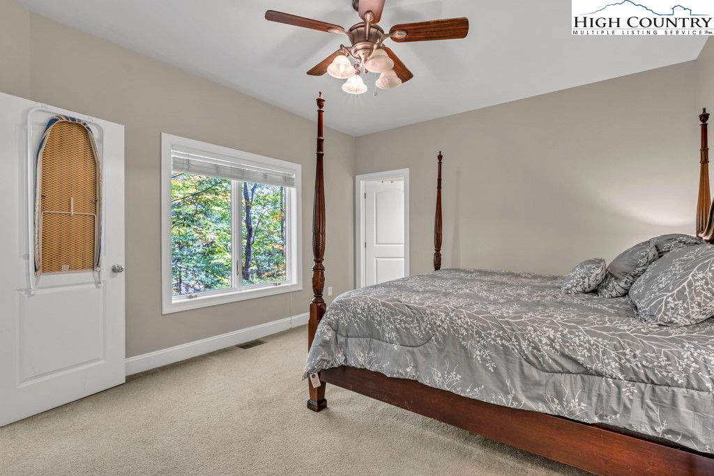 100 Northridge Road Beech Mountain, NC 28604 - Photo 15 of 32 a bedroom with a bed and a chandelier