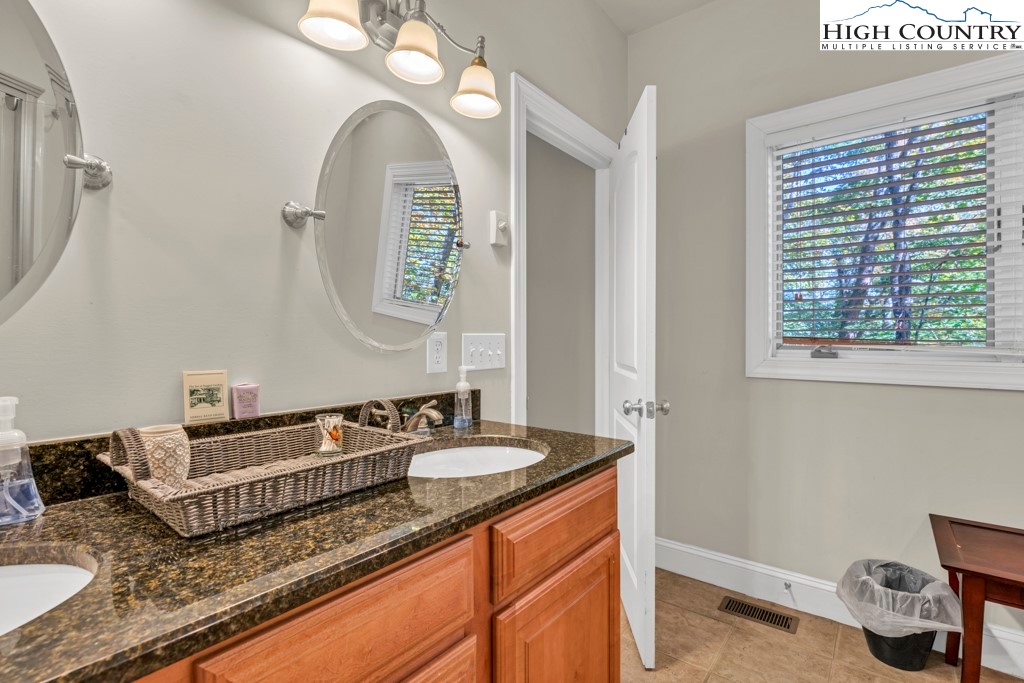 100 Northridge Road Beech Mountain, NC 28604 - Photo 16 of 32 a bathroom with a granite countertop sink and a mirror