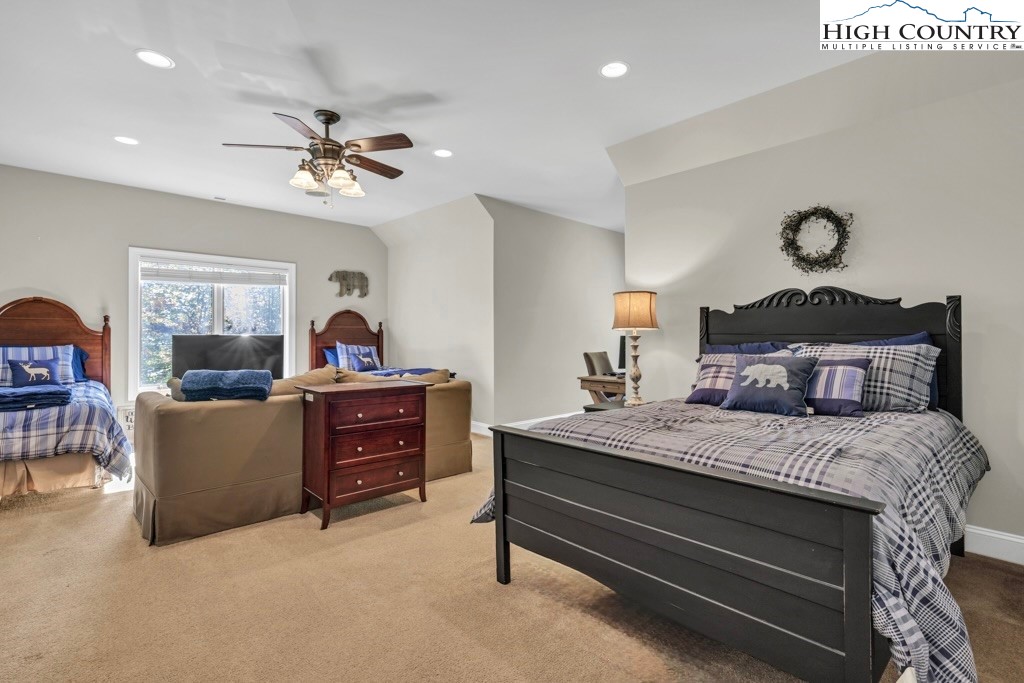 100 Northridge Road Beech Mountain, NC 28604 - Photo 18 of 32 a bedroom with a bed and a chandelier