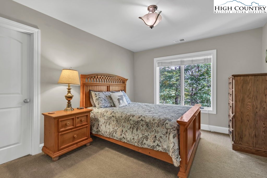 100 Northridge Road Beech Mountain, NC 28604 - Photo 21 of 32 a bedroom with a bed and a chandelier