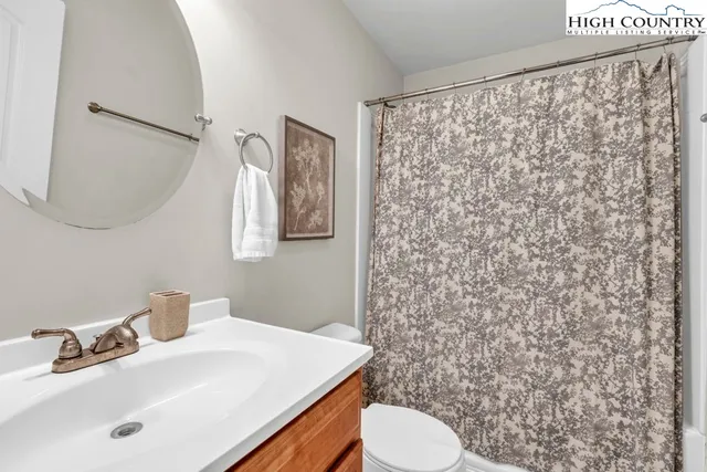 a bathroom with a sink a toilet and shower curtain