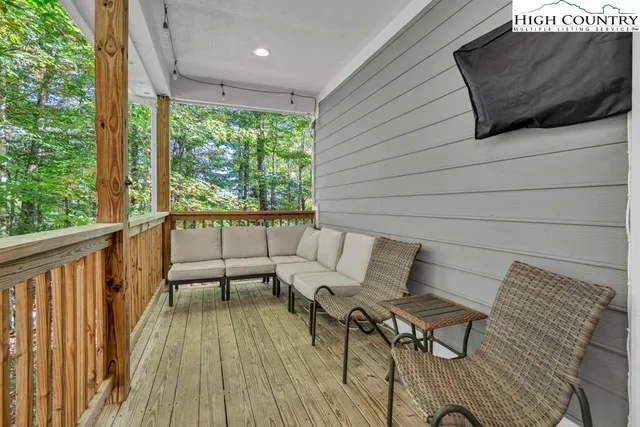 a view of a patio with table and chairs with wooden floor and fence