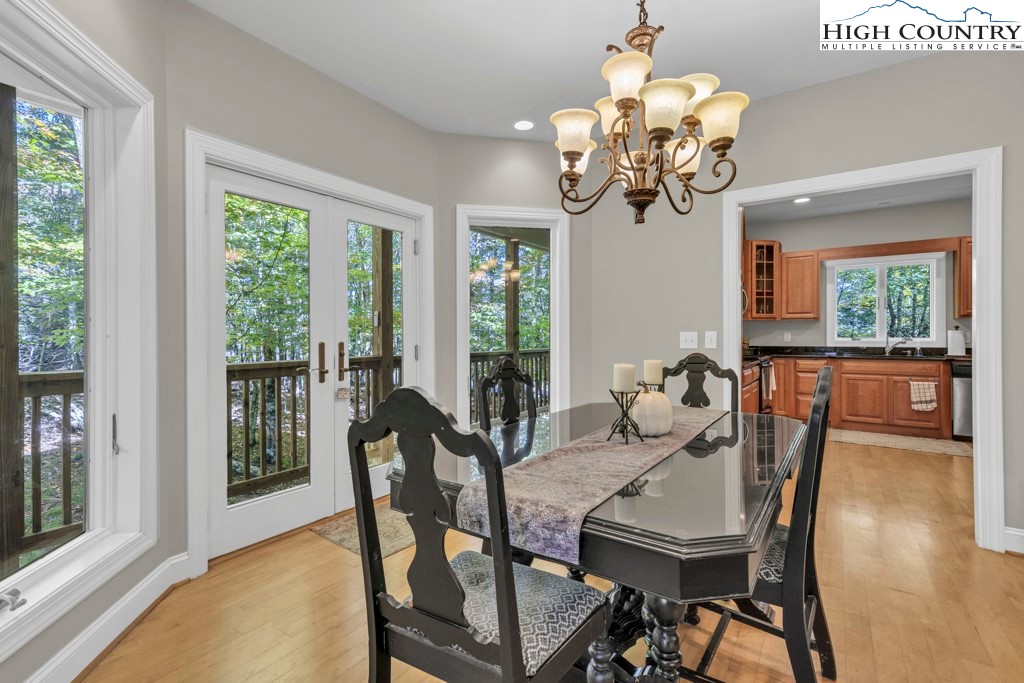 100 Northridge Road Beech Mountain, NC 28604 - Photo 8 of 32 a view of a dining room with furniture a chandelier and large windows