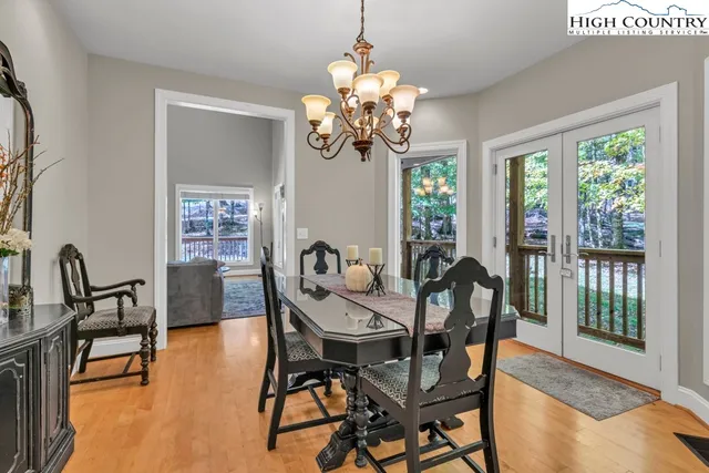 a dining room with furniture a large window and wooden floor