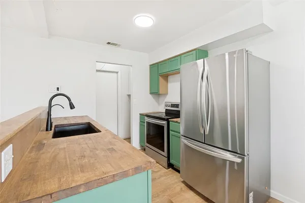 a kitchen with granite countertop a refrigerator and a sink