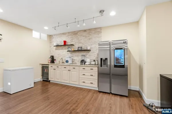 a kitchen with stainless steel appliances a sink and wooden floors