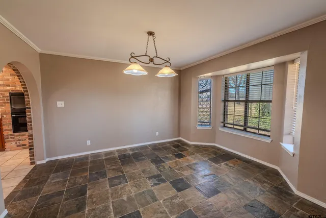 a large white kitchen with a large counter space a sink stainless steel appliances and cabinets