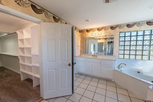 a bathroom with a bathtub shower sink vanity and toilet