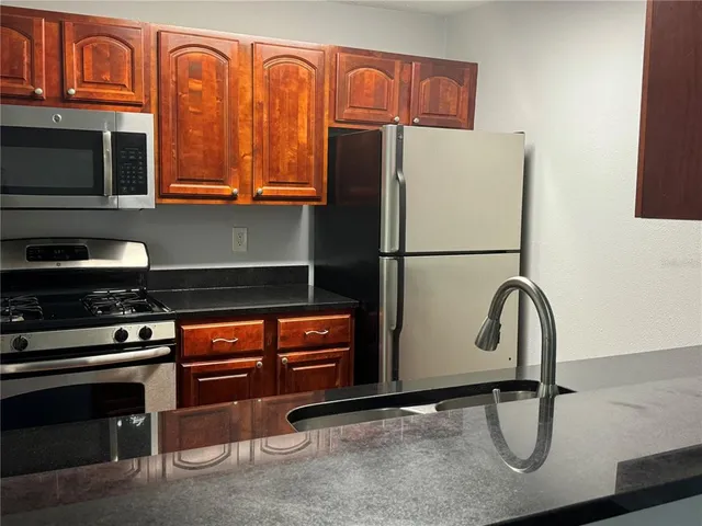 a kitchen with wooden cabinets and a stove top oven