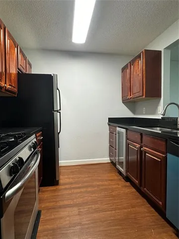 a kitchen with stainless steel appliances granite countertop a refrigerator and a stove top oven