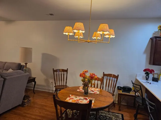 a view of a dining room with furniture a chandelier and wooden floor