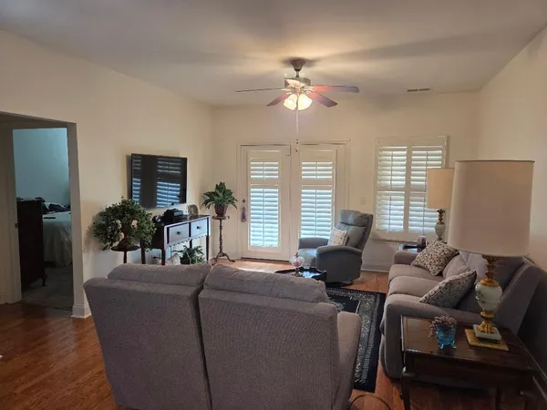 a living room with furniture a chandelier and a flat screen tv