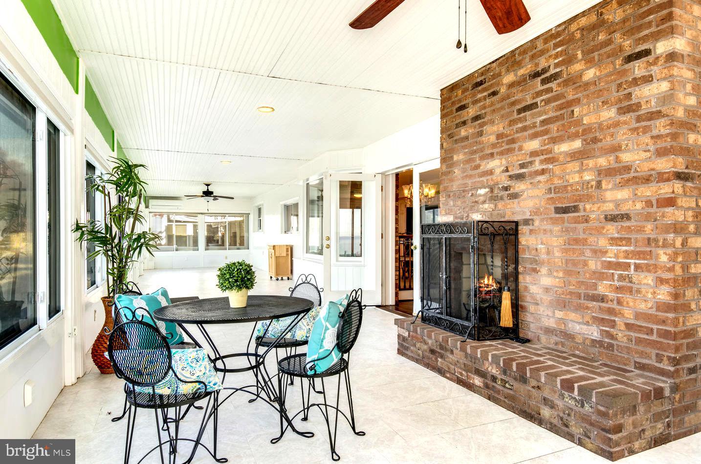3202 Bennett Point Road Queenstown, MD 21658 - Photo 24 of 49 Doors Spilling into Sunroom with Brick Hearth