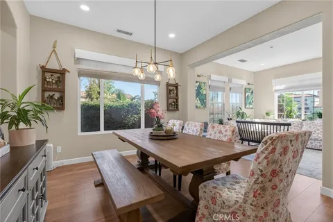 a kitchen with stainless steel appliances granite countertop a table chairs sink and cabinets