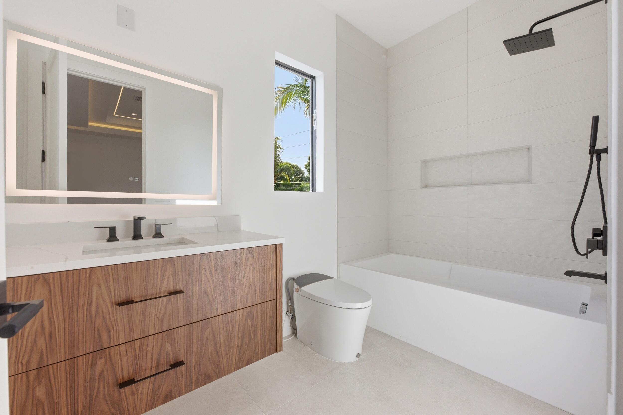 2360 Northeast 49th Street Lighthouse Point, FL 33064 - Photo 49 of 66 a bathroom with a bathtub shower sink vanity and toilet