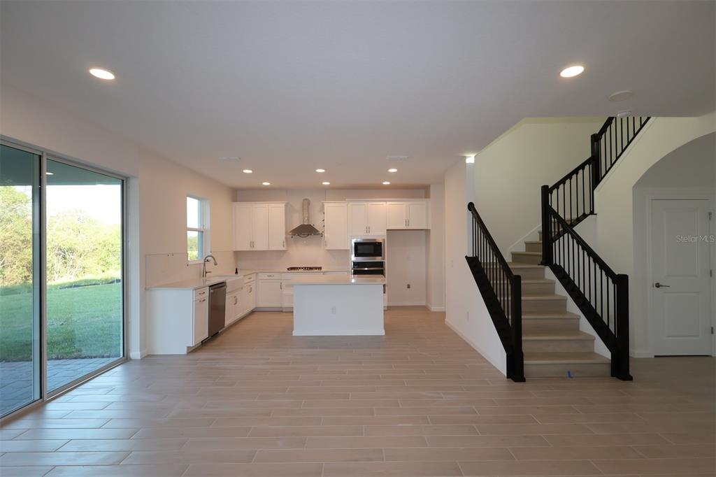 5426 Park Guell Street St. Cloud, FL 34771 - Photo 20 of 64 a open kitchen with white cabinets a sink and a floor to ceiling window