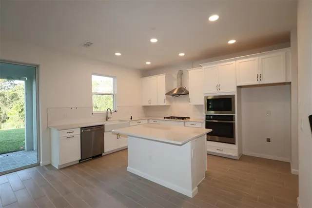 a kitchen with stainless steel appliances granite countertop a stove and a refrigerator