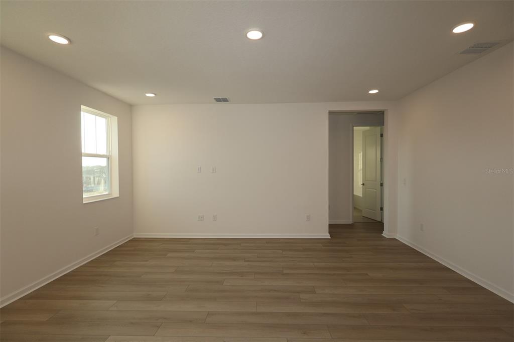 5426 Park Guell Street St. Cloud, FL 34771 - Photo 51 of 64 an empty room with wooden floor and windows