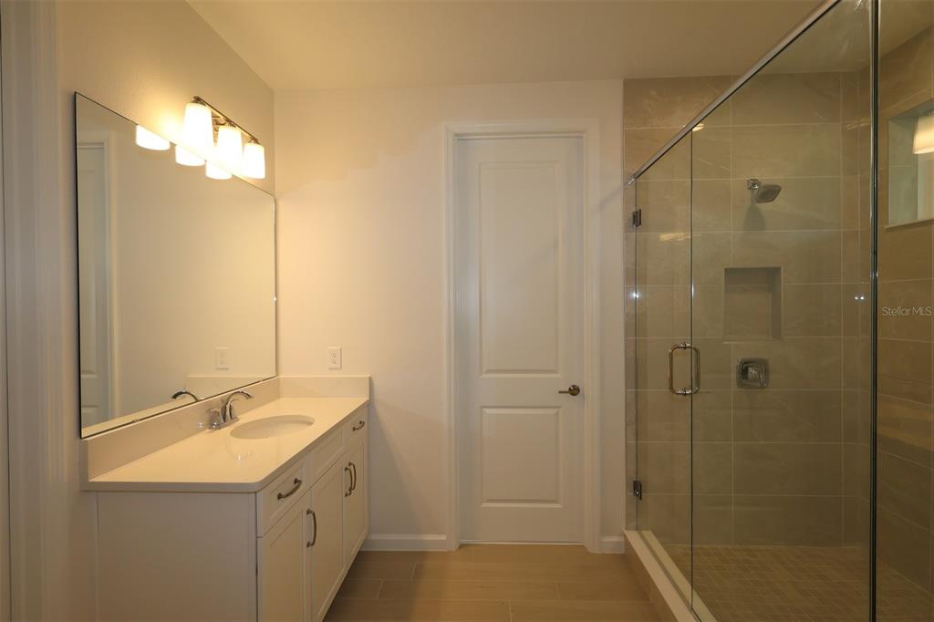 5426 Park Guell Street St. Cloud, FL 34771 - Photo 55 of 64 a bathroom with a double vanity sink and shower